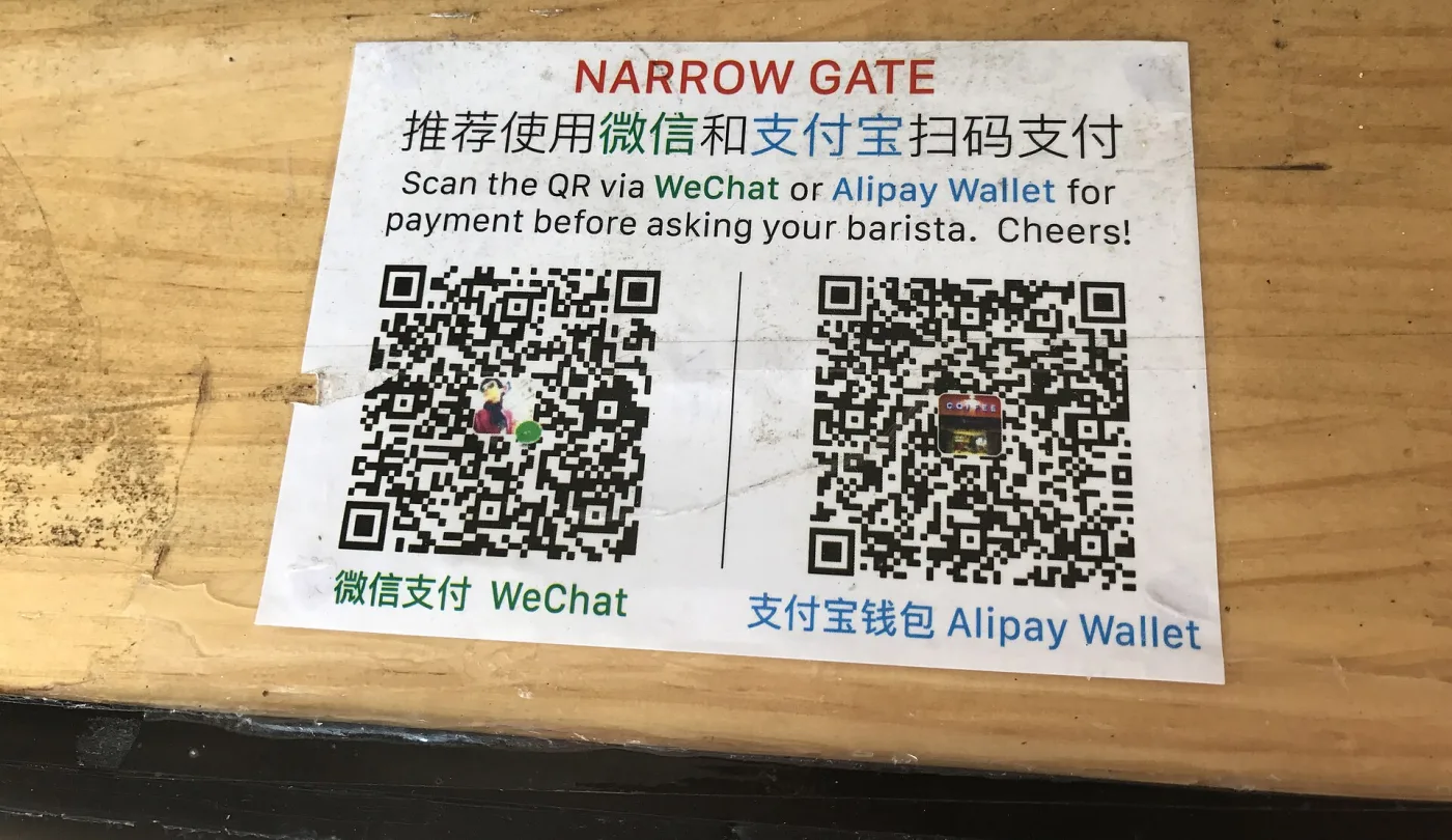 Табличка с QR-кодами WeChat и Alipay на стойке кафе в Китае — так здесь принимают оплату