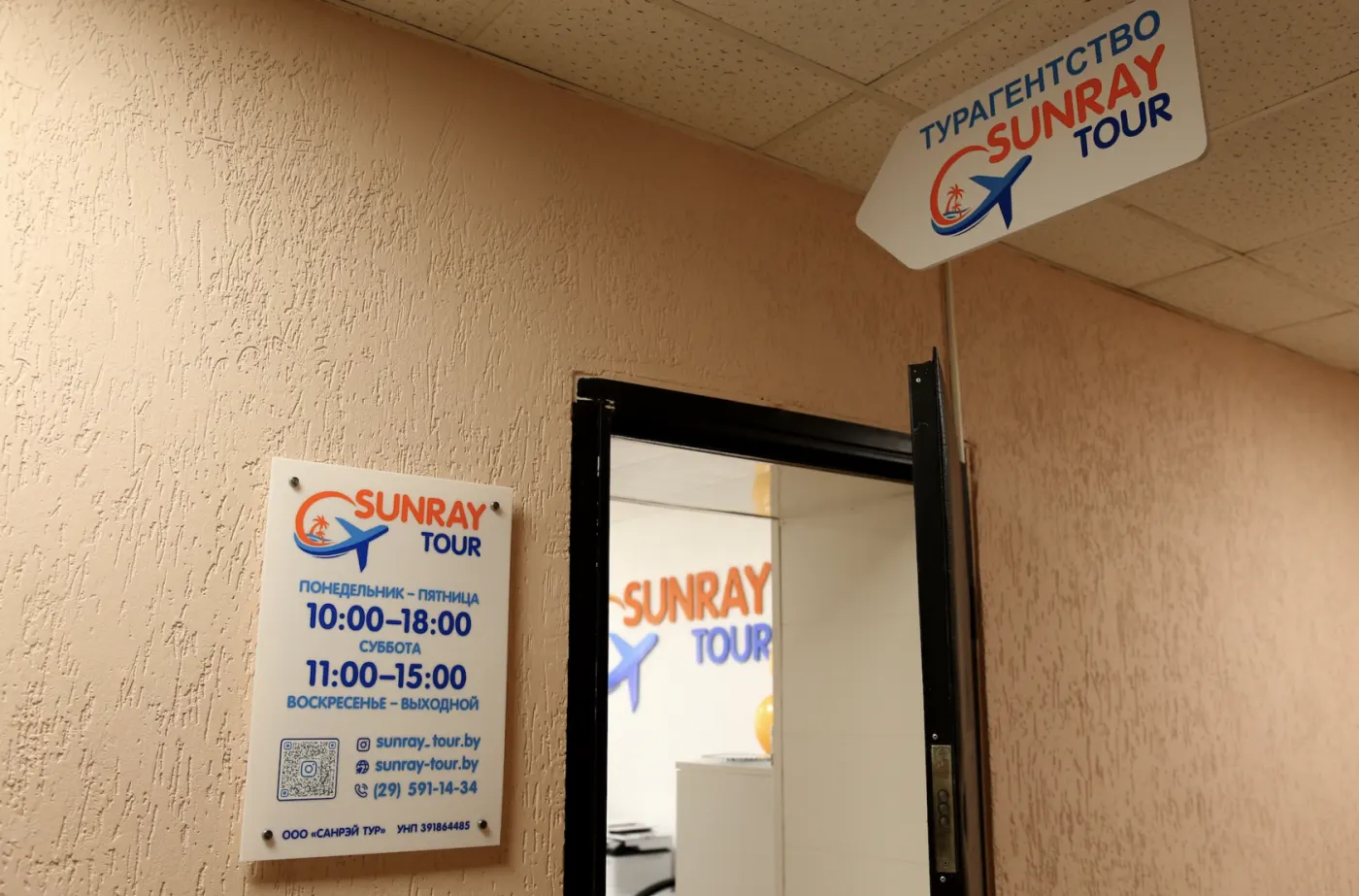 Вход в офис турагентства SUNRAY TOUR в Витебске с табличкой и часами работы